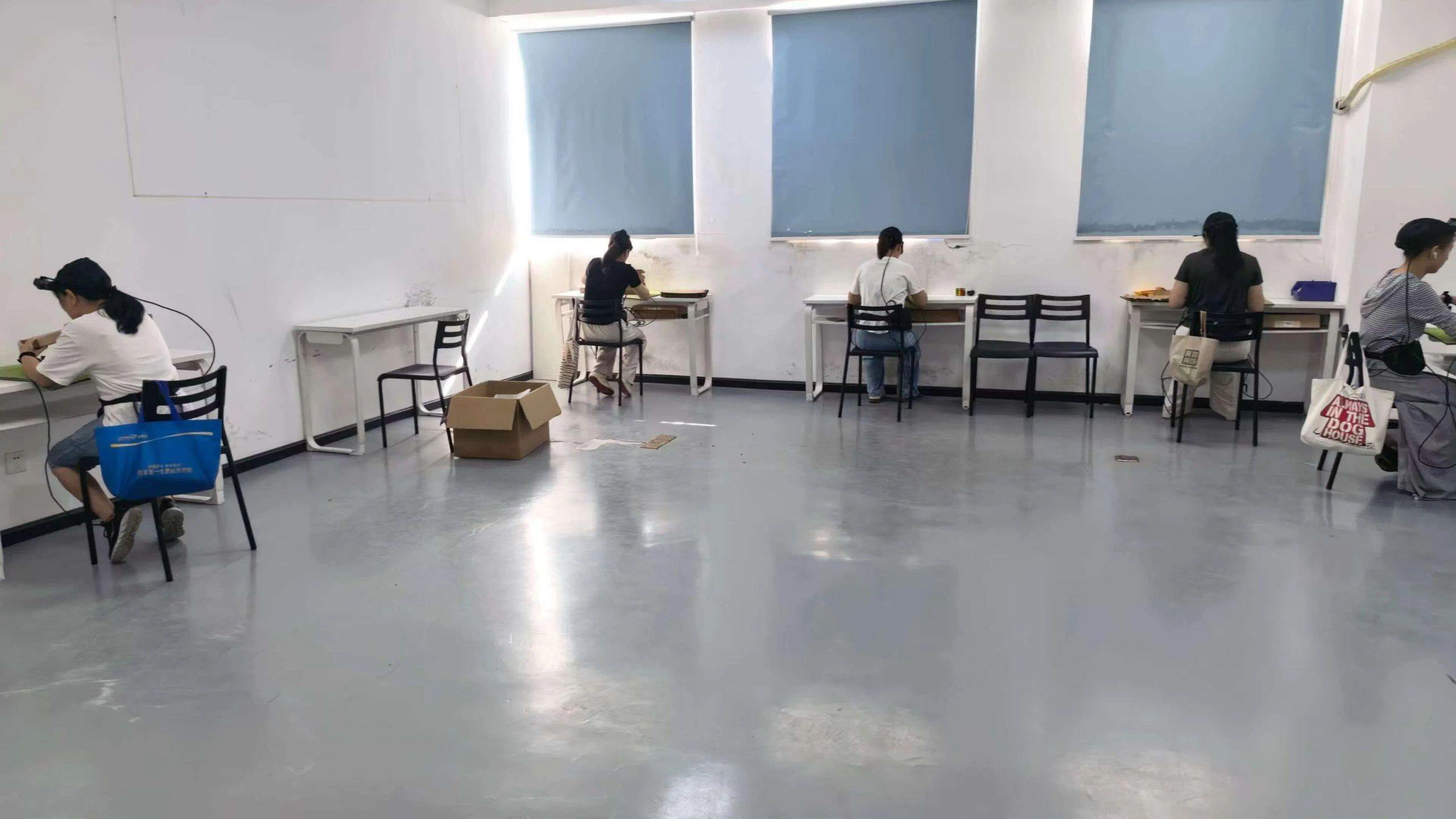 数采员坐在工位前,反复进行桌面物品拿取、整理等操作,用头戴设备记录手部动作。(受访者提供) 数采员坐在工位前,反复进行桌面物品拿取、整理等操作,用头戴设备记录手部动作。(受访者提供)