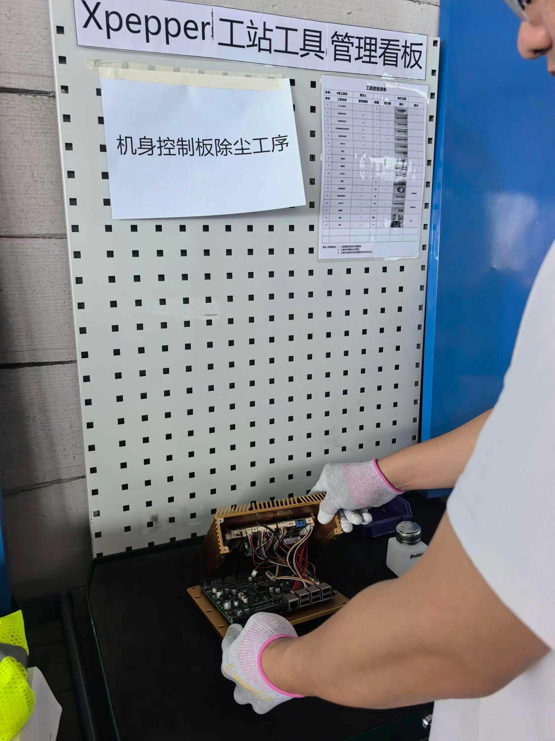 数据采集员头戴摄像头完成机身控制板除尘,记录下双手操作过程,让机器人从真实作业中“学习”这一工序。(受访者提供) 数据采集员头戴摄像头完成机身控制板除尘,记录下双手操作过程,让机器人从真实作业中“学习”这一工序。(受访者提供)